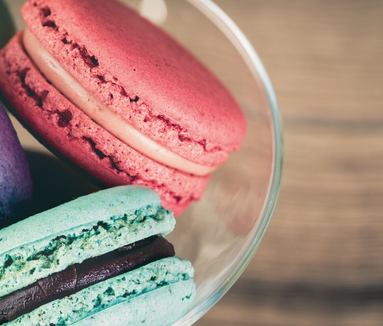 Macarons in a dish, pastel coloured.
